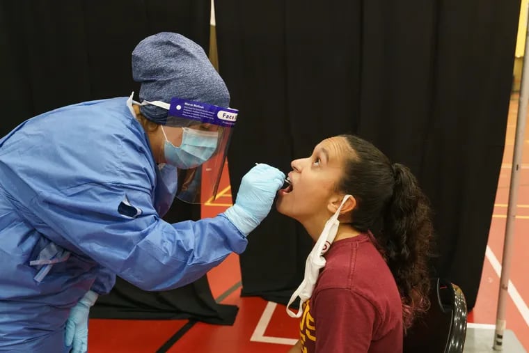Registered Nurse Heather Leets, left, administers a COVID19 test to student Kayla Ruiz at Ursinus College, where the fall semester is underway.