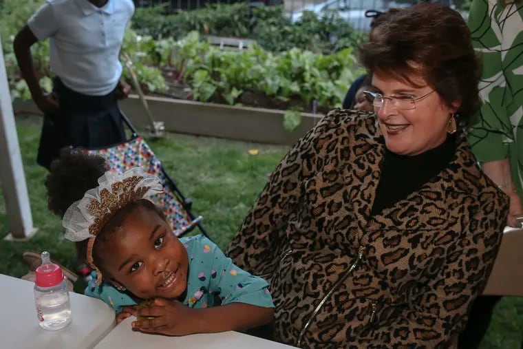 Philanthropist Dana Dornsife sits with Londyn Wylaie, 4, during the free monthly community dinner at the Dornsife Center for Neighborhood Partnerships, part of Drexel's School of Public Health. Dana and her husband, David, gave $10 million to create the center.