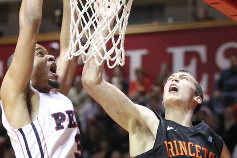Penn forward Henry Brooks dunks over Princeton's Denton Koon for two of his eight points on Monday night. The Quakers trampled the Tigers, 82-67, to remain unbeaten in the Ivy League.