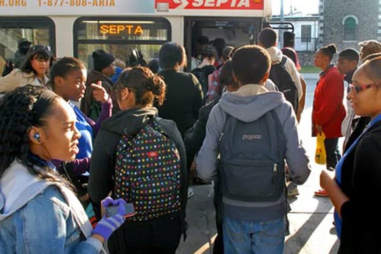Commuters board SEPTA city division buses at the Frankford Transportation Center this morning. ( Tom Gralish / Staff Photographer )