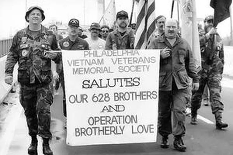 Vietnam vets returning from Washington, where they traced the names of what, at the time, were believed to be the 628 Philadelphians who died in Vietnam and who were listed on the Vietnam memorial wall, march across the Platt Bridge on their way to Veterans Stadium in May 1987.