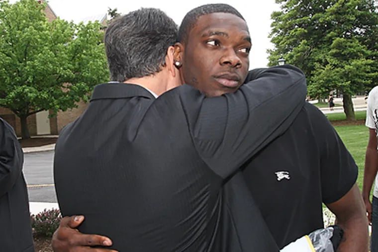 Kimani Barrett, center, gets a hug from his coach, John Giannini. (Michael Bryant / Staff Photographer)