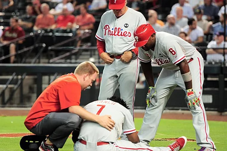 Philadelphia Phillies third baseman Maikel Franco (7) is tended to after being hit by a pitch against the Arizona Diamondbacks as Philadelphia Phillies interim manager Pete Mackanin (45) and Philadelphia Phillies first baseman Ryan Howard (6) look on during the first inning at Chase Field. (Joe Camporeale/USA Today)