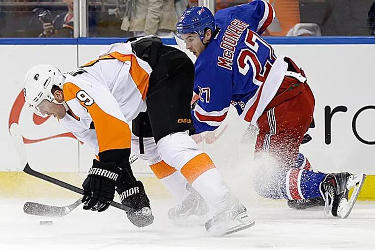 The  Rangers' Ryan McDonagh and the Flyers' Scott Hartnell scramble for the puck during the first period. (Seth Wenig/AP)