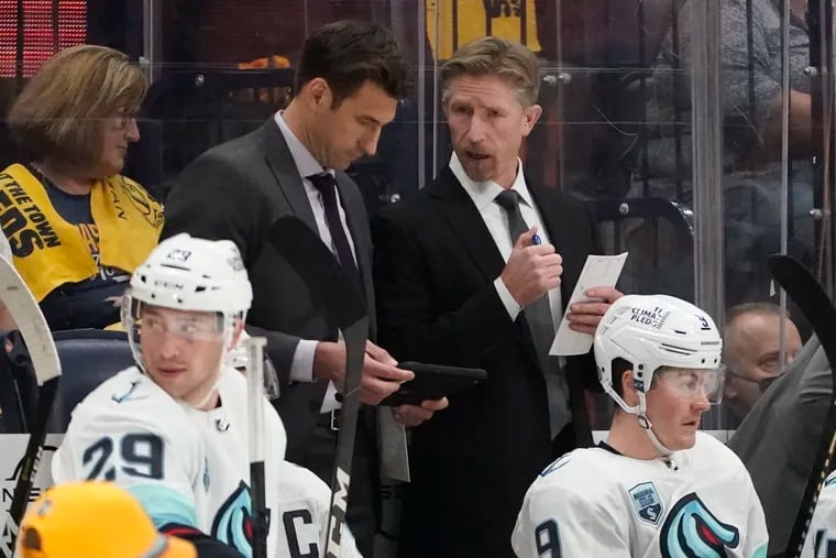 Seattle Kraken head coach Dave Hakstol, center right, talks with assistant coach Jay Leach in the second period of an NHL game against the Nashville Predators on Thursday. Seattle notched the first win in franchise history that night.
