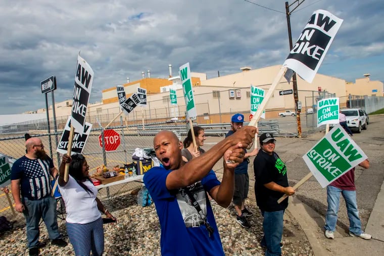Flint resident Jashanti Walker, who has been a first shift team leader in the body shop for two years, demonstrates with more than a dozen other General Motors employees outside of the Flint Assembly Plant on Sunday in Flint, Michigan.