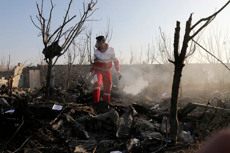 A rescue worker searches the scene where a Ukrainian plane crashed in Shahedshahr, southwest of the capital Tehran, Iran, on Wednesday.