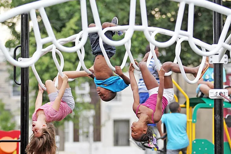 Kids hang upside down from a playground structure at McPherson Square Park in Kensington on Tuesday, Aug. 6, 2013. (Yong Kim/Staff)