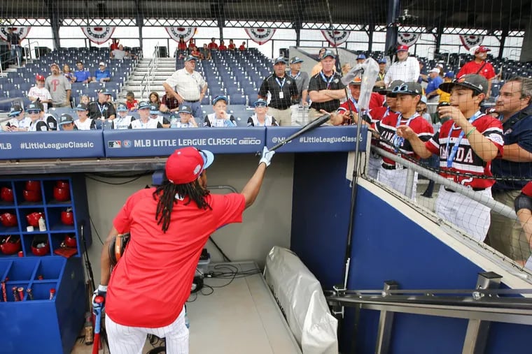 Maikel Franco hands over his bat to members of the Canadian team at BB&T Ballpark at Historic Bowman Field on Sunday ahead of the Phillies-Mets game.