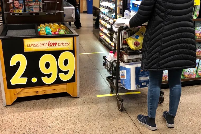 Taped lines help customers waiting in checkout lines practice social distancing at the Wegmans in Mount Laurel, N.J., on Tuesday, March 24, 2020. Some stores are taking measures to reduce risk of the coronavirus spreading.