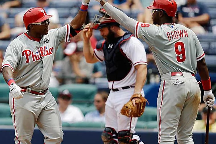 Marlon Byrd, left, is high-fived by teammate Domonic Brown after hitting a home run in the eighth inning of a baseball game against the Atlanta Braves, Wednesday, June 18, 2014, in Atlanta. (David Goldman/AP)