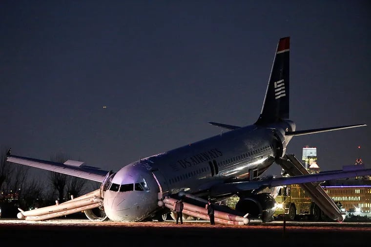 Investigators examine a US Airways jet after an aborted takeoff in 2014. A report was issued recently.