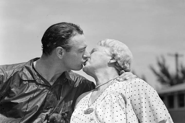 Lou Gehrig, of the New York Yankees, gets a big kiss from his mother Christina when the ace first baseman reported for spring practice at St. Petersburg, Fla., March 16, 1938. Gehrig recently signed a $39,000 contract.