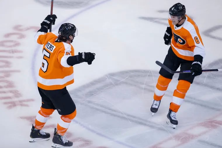 Flyers defenseman Phil Myers (left) celebrates his game-winning goal in overtime with teammate defenceman Travis Sanheim.