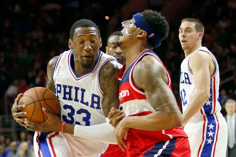 Sixers' Robert Covington charges into Wizards' Bradley Beal.  YONG KIM/Staff Photographer