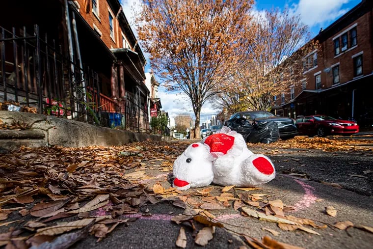A teddy bear lies as a memorial on the location where Samuel Collington was shot and killed last year near Temple's campus.