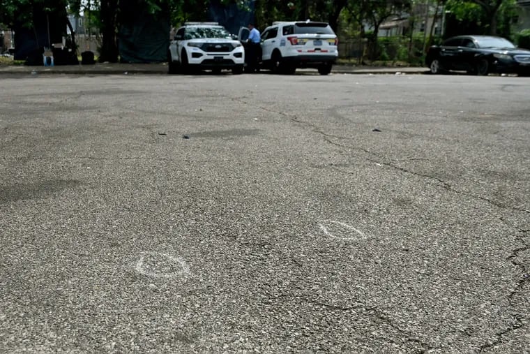 Police investigator’s chalk circles marking shell casings remain in the cul-de-sac in the 500 block of N. Creighton Street on Monday. Several gunmen fired at least 60 bullets through a crowd at a cookout in the street over the weekend that left 9 people shot, including one man who died.