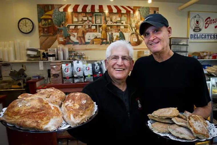 Hymie's worker Joel Chesney with turkey breasts and manager Harry Zeisler with latkes.