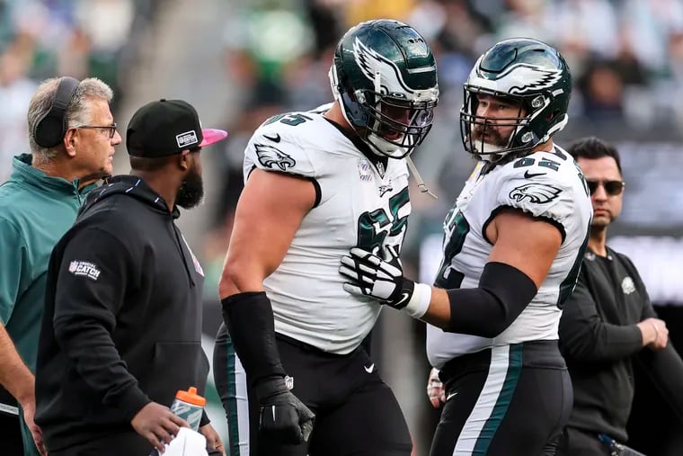 Eagles center Jason Kelce (right) talks to offensive tackle Lane Johnson as he limps off after suffering an ankle injury in the first quarter against the New York Jets.