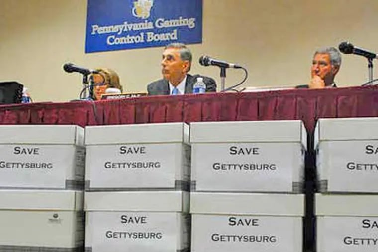 Piles of petitions against the proposed Gettysburg casino line a table as the Gaming Control Board hears testimony earlier this week. (Tom Gralish / Staff Photographer)