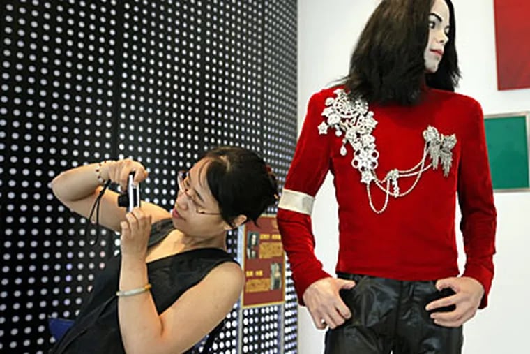 A visitor next to a wax figure of Michael Jackson at the Madame Tussauds Wax Museum in Shanghai. Jackson's death at the age of 50 has captured worldwide attention. (AP Photo/Eugene Hoshiko)