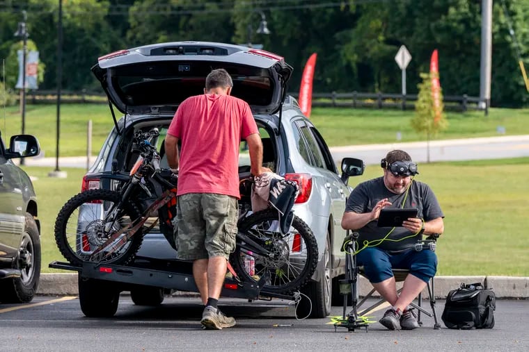 Amateur drone pilot Ryan Davis (right) of Edgewater, Md., working in the parking lot of the Wawa at the intersection of Routes 401 and 100 in Chester Springs on Sunday.