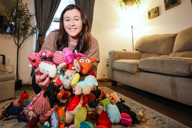 Caitlin Parylak surrounded by dog toys inside her Northeast Philadelphia home.