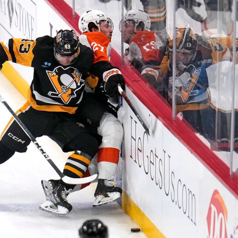 Pittsburgh's Jansen Harkins knocks the Flyers' Noah Cates off the puck during the first period Sunday.