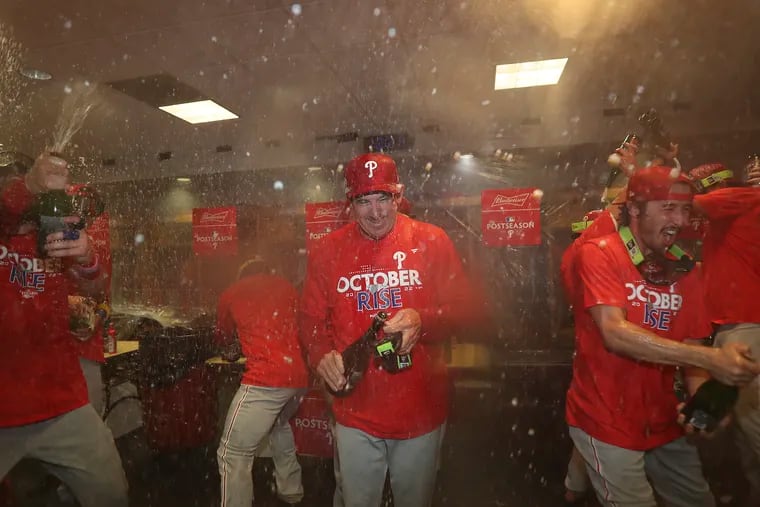 Phillies manager Rob Thomson celebrates with his players after the team beat the Houston Astros to clinch a spot in the postseason.