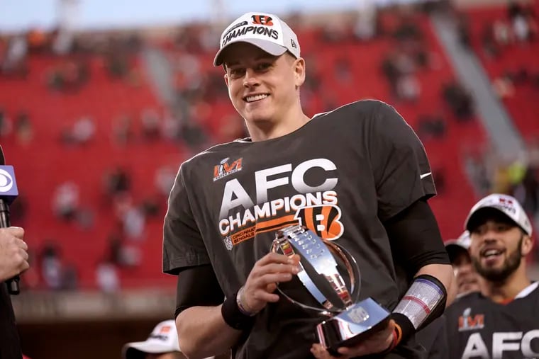 Quarterback Joe Burrow holds the Lamar Hunt trophy after the Cincinnati Bengals beat the Kansas City Chiefs, 27-24, in overtime for the AFC championship.