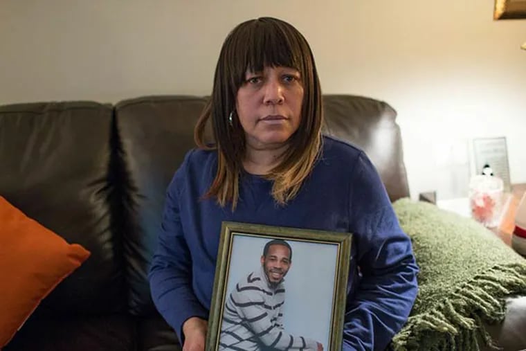 Carolyn Moses holds a photograph of her son, Jamil Moses, in her home in Northeast Philadelphia. Jamil was shot to death on February 8, 2011, after police boxed in the stolen car in which he was a passenger. (COLIN KERRIGAN / Philly.com)