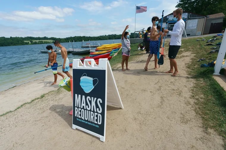 A sign at Marsh Creek Water Sports in Downingtown on Friday reminds kayakers to wear masks.
