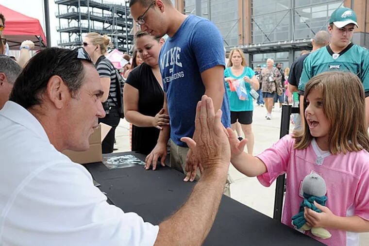 Former Philadelphia Eagles tight end John Spagnola gives  Brielle Albus, 8, of Northampton a high-five before signing an autograph in 2013. Spagnola is a managing director of a firm that has won a contract to manage $2.6 billion in NFL retirement plans.