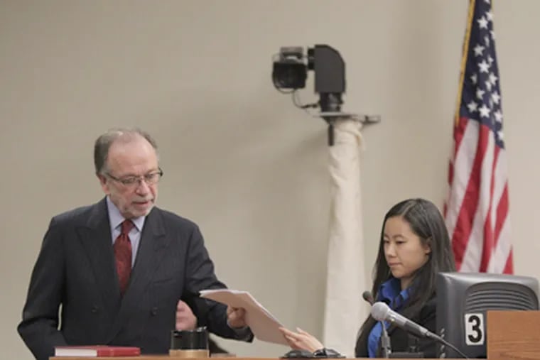 Defense attorney Steven Altman hands Molly Wei a copy of her statement to police during the trial of Dharun Ravi, charged with spying on his Rutgers roommate during an intimate encounter. (JOHN O'BOYLE / Newark (N.J.) Star-Ledger, Pool)