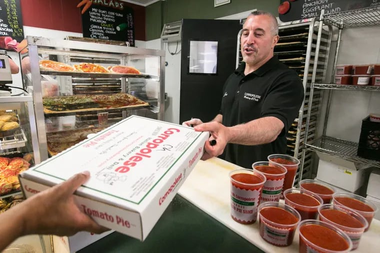 Joe Corropolese hands a customer a tomato pie at Corropolese Bakery in East Norriton.