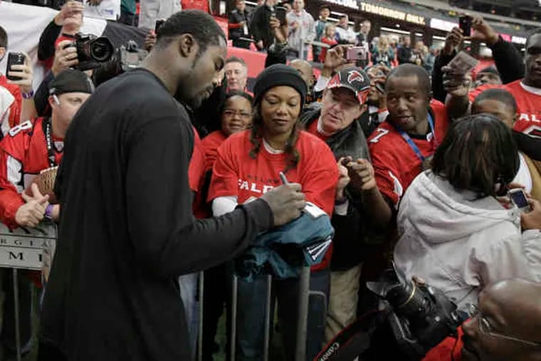 Eagles quarterback Michael Vick signs autographs at Georgia Dome before game with Falcons.