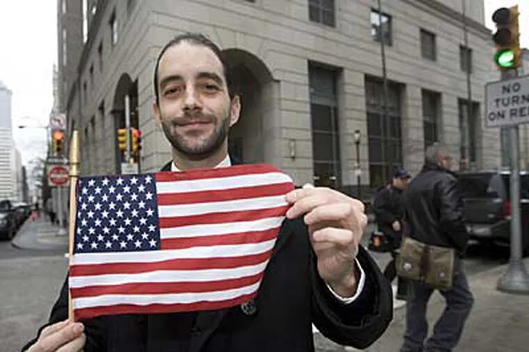 Ralph Silvestro, a legal clerk who works at the front counter at the Criminal Justice Center, is shown here with a American flag. (Jessica Griffin /
Staff Photographer)