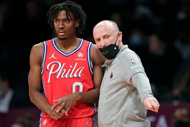 Philadelphia 76ers assistant coach Dan Burke talks to Tyrese Maxey during the first half of an NBA basketball game against the Brooklyn Nets on Thursday, Dec. 30, 2021, in New York. (AP Photo/Adam Hunger).