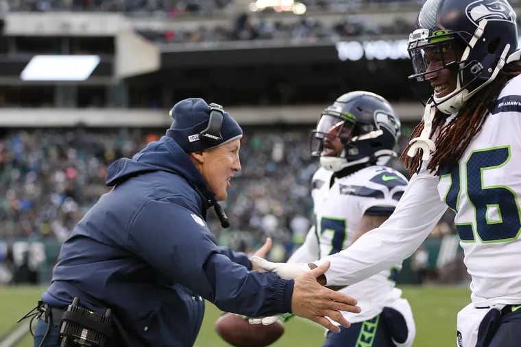 Seahawks coach Pete Carroll congratulates strong safety Quandre Diggs (37) and cornerback Shaquill Griffin (26) after Diggs recovered a fumble against the Eagles at Lincoln Financial Field in November.