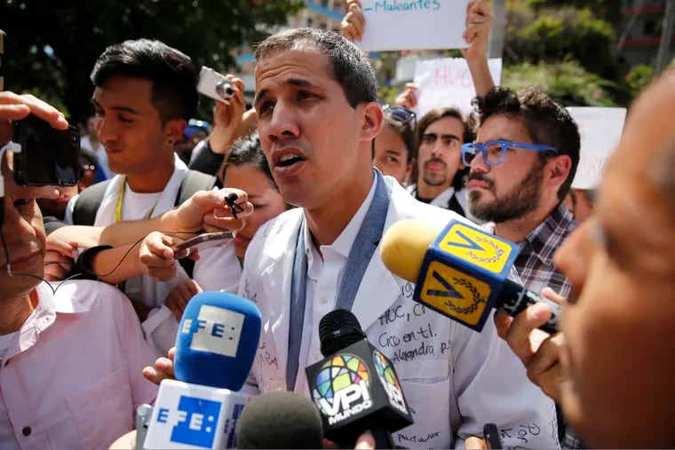 Opposition National Assembly President Juan Guaido, who declared himself interim president of Venezuela, speaks to reporters during a walk out against President Nicolas Maduro, in Caracas, Venezuela, Wednesday, Jan. 30, 2019. Venezuelans are exiting their homes and workplaces in a walkout organized by the opposition to demand that Maduro leave power.