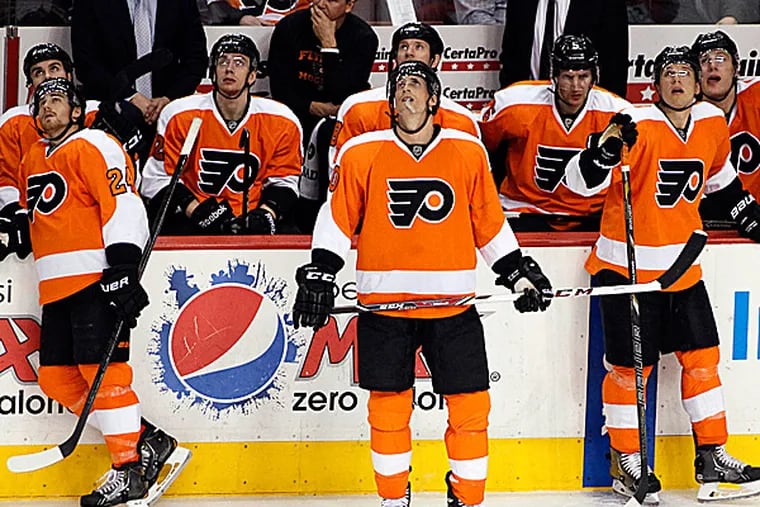 The Flyers bench look up at the scoreboard. (Tom Mihalek/AP)