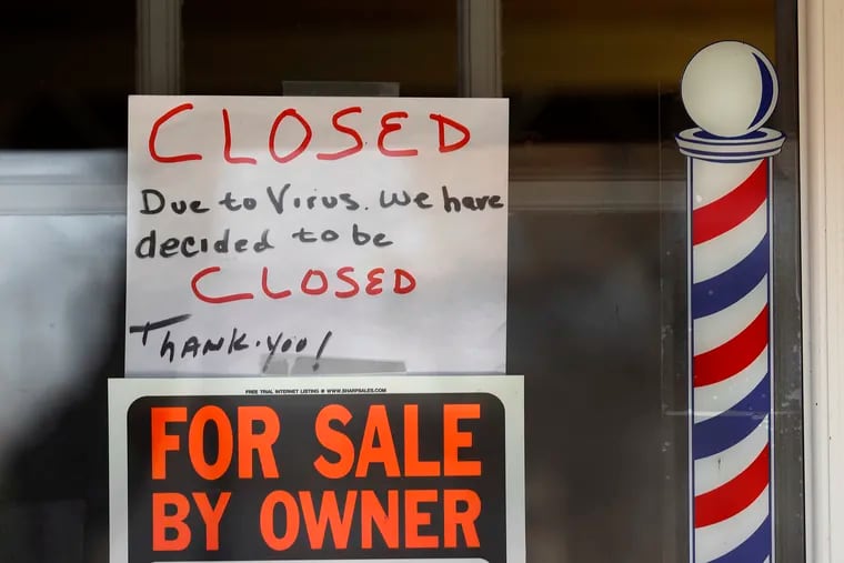"For Sale By Owner" and "Closed Due to Virus" signs are displayed in the window of a store in Grosse Pointe Woods, Mich.