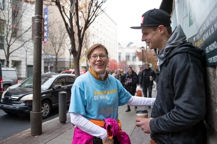 Teresa Giuliana, an ambassador of hope with Project Home, gives coffee to a homeless man named Matt outside of Reading Terminal Market on Friday, Nov. 22, 2019. When vendors of the Reading Terminal had noticed an uptick in the number of homeless people in the market this spring, they turned to Sister Mary Scullion of Project Home, who appointed Giuliana to be the ambassador at the terminal.  The program has made contact with 300 people in the past few months, placing 30 of them into housing and mental health services.