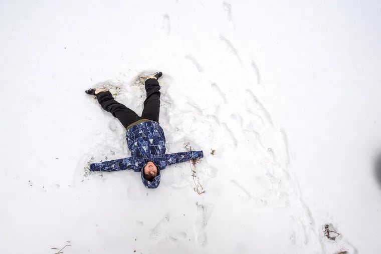 Bode Ouellette, age 10, lies in the snow and forms an angel with his arms and legs in Wallingford on Monday.