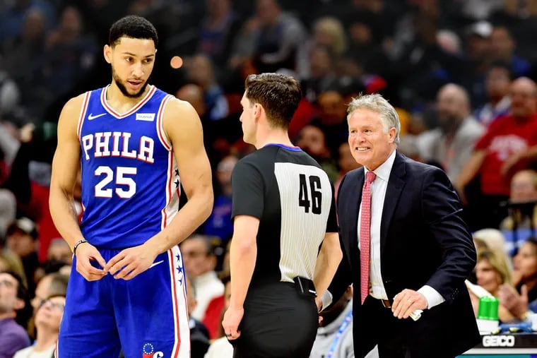 Sixers coach Brett Brown (right) reacting to a call by referee Ben Taylor (center) during a December game against the Jazz.