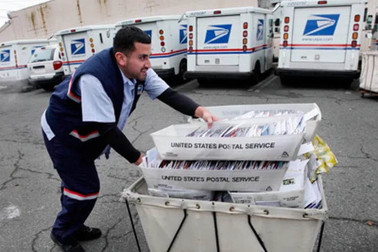 Letter carrier Felipe Raymundo moves a cart of mail to his truck to begin delivery Monday, Dec. 5, 2011, at a post office in Seattle. The cash-strapped U.S. Postal Service said Monday it is seeking to move quickly to close 252 mail processing centers and slow first-class delivery next spring, citing steadily declining mail volume. (AP Photo/Elaine Thompson)