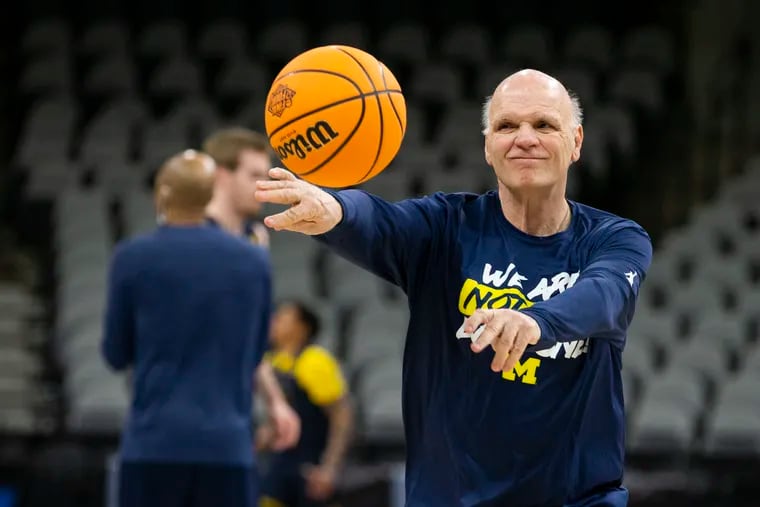 Associate coach Phil Martelli of Michigan passes the ball to players as they practice Wednesday at AT&T Arena in San Antonio.