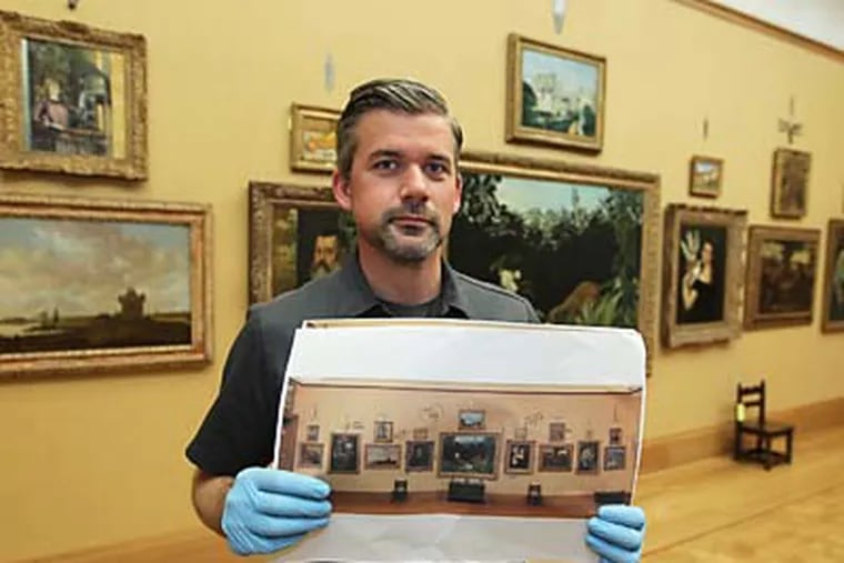 Tim Gerschick, a Barnes Museum art handler/collections assistatnt, holds his reference photo for the upstaris gallery at the new Barnes Collections Gallery in Philadelphia. Tim uses these photographs from the Merion Gallery to place the artwork back in exactly the same place position in the new galleries downtown.  ( MICHAEL BRYANT / Staff Photographer )