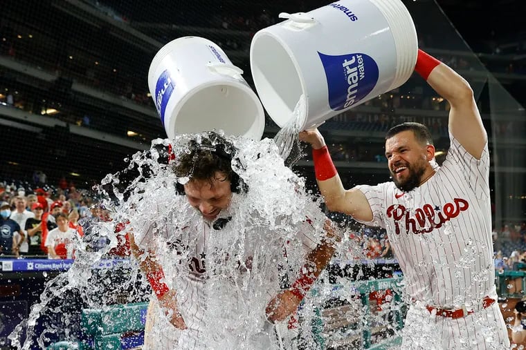 Rhys Hoskins gets the water bath from Kyle Schwarber and Bryson Stott after hitting the game-winning double to beat the Marlins on Monday.
