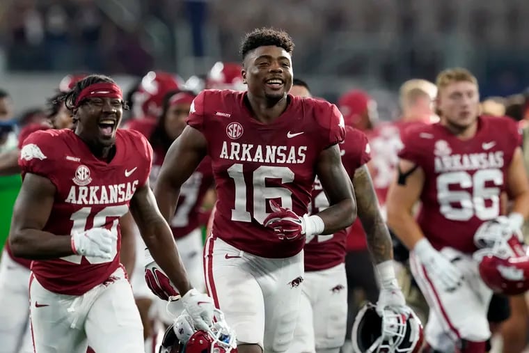 Arkansas wide receiver Treylon Burks (16) and teammates celebrate after their win in an NCAA college football game against Texas A&M in Arlington, Texas, Saturday, Sept. 25, 2021. (AP Photo/Tony Gutierrez)
